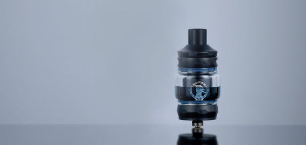 GeekVape Zeus Z Nano 2 Tank vape part with glass chamber, metal base, and adjustable airflow in a close-up view.